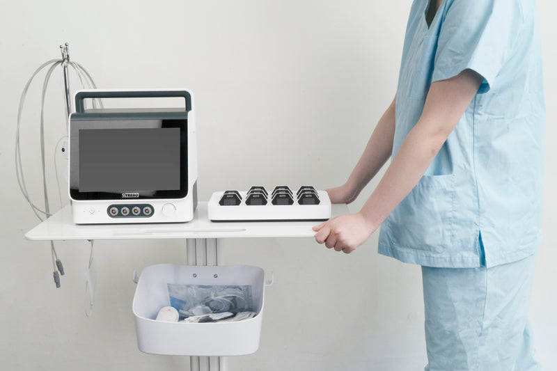 Low and medium frequency electrotherapy system displayed on a treatment cart with a healthcare professional.